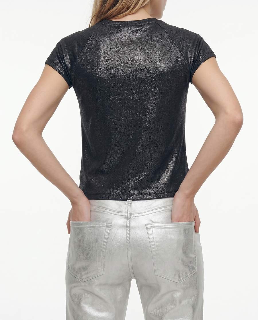 Plano medio de espalda: la remera brillante y el jean plateado