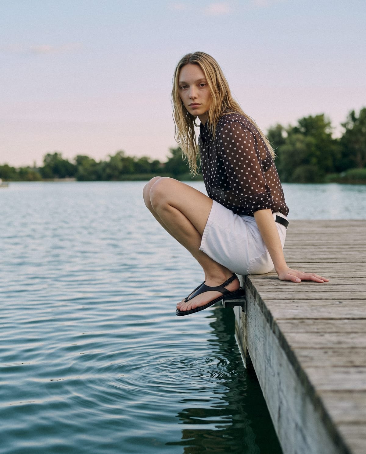 Koxis: blusa de lunares, en cuclillas al borde del muelle